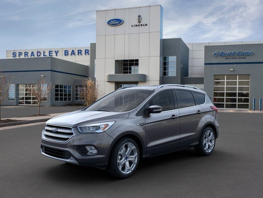 A gray Ford SUV parked outside of a Ford dealership.