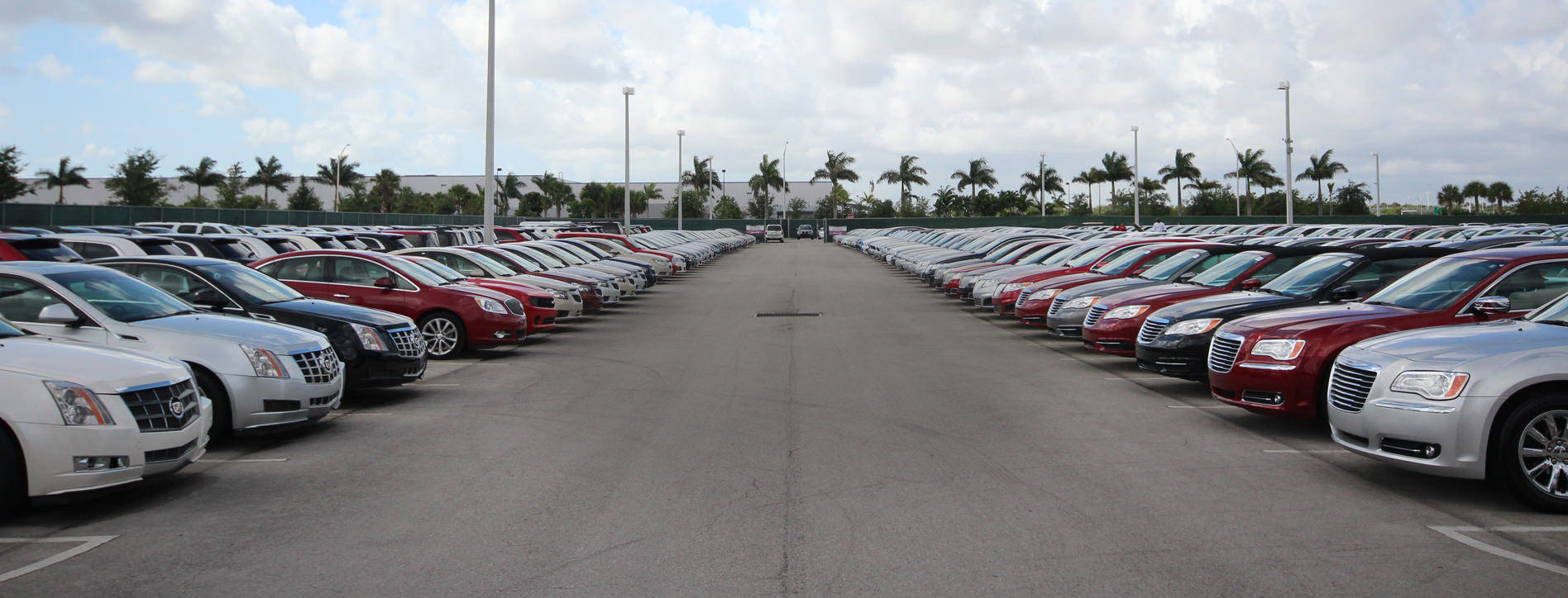 A parking lot filled with various types and brands of cars.