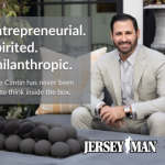 Dave Cantin, an entrepreneurial, spirited, and philanthropic speaker, wearing a tan suit posing for Jersey Man and Philly Man.